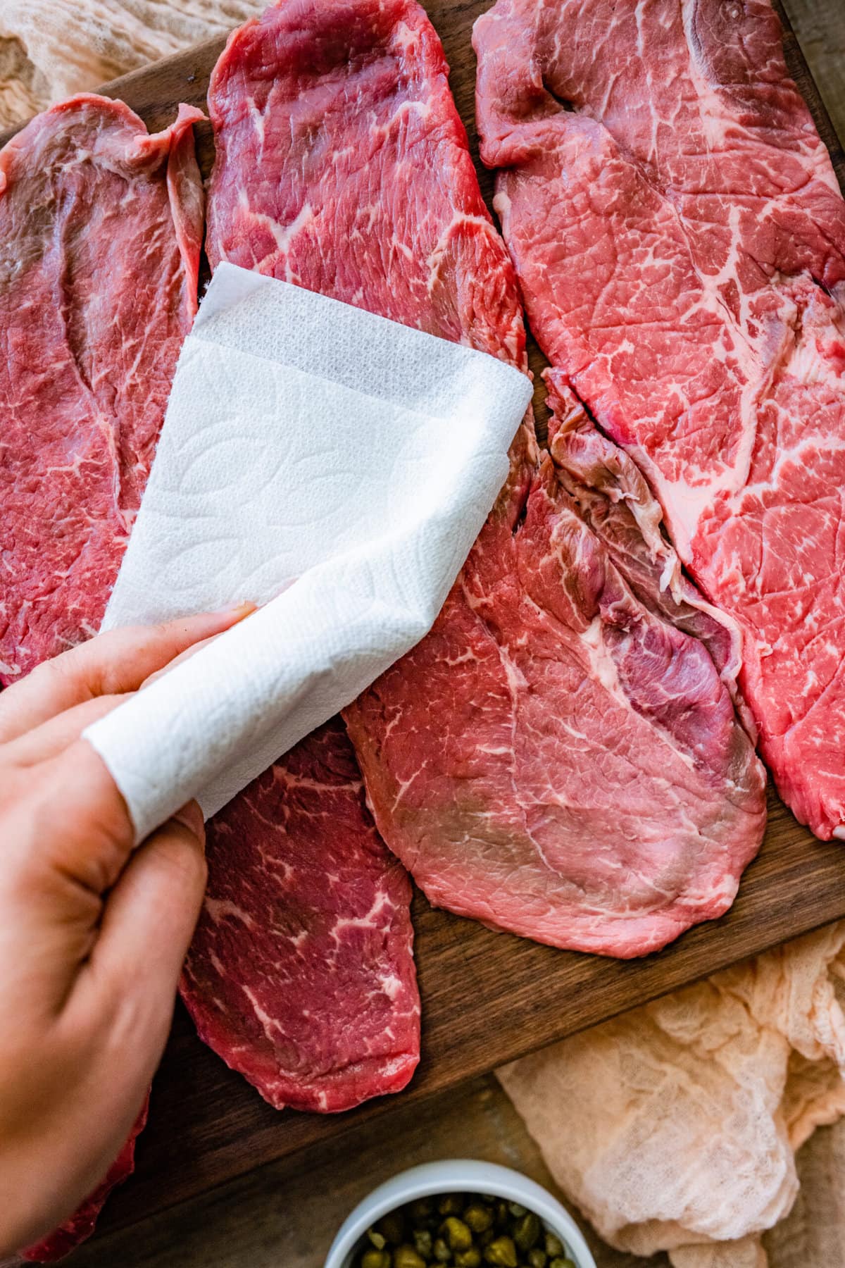 How to make steak pizzaiola step by step- patting the steaks dry.