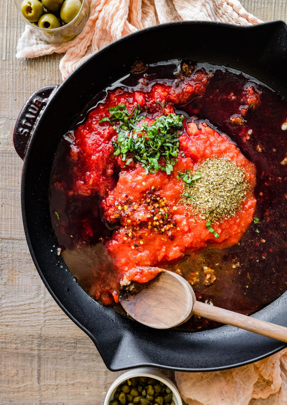 How to make steak pizzaiola step by step- adding the tomato sauce and seasonings to the pan.