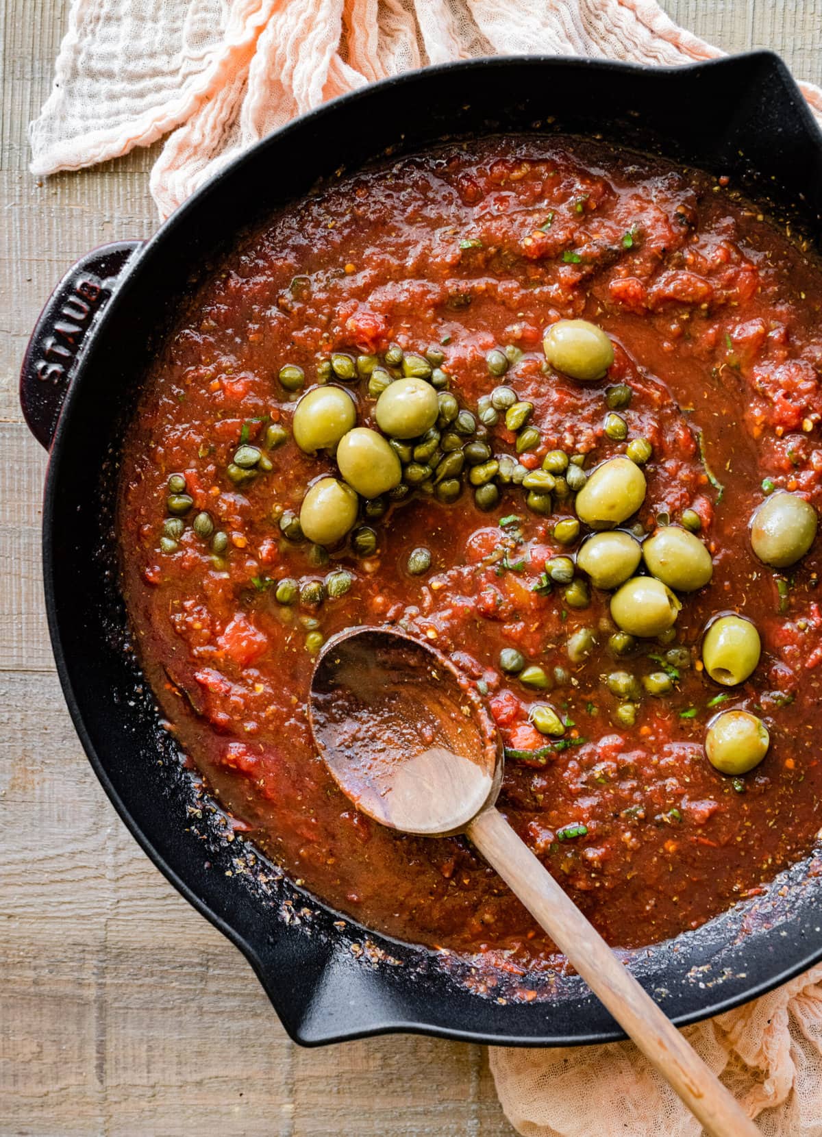 How to make steak pizzaiola step by step- adding the olives and capers.