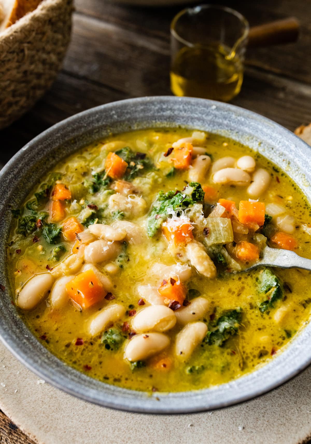 close up of the tuscan white bean soup in a beautiful soup bowl.