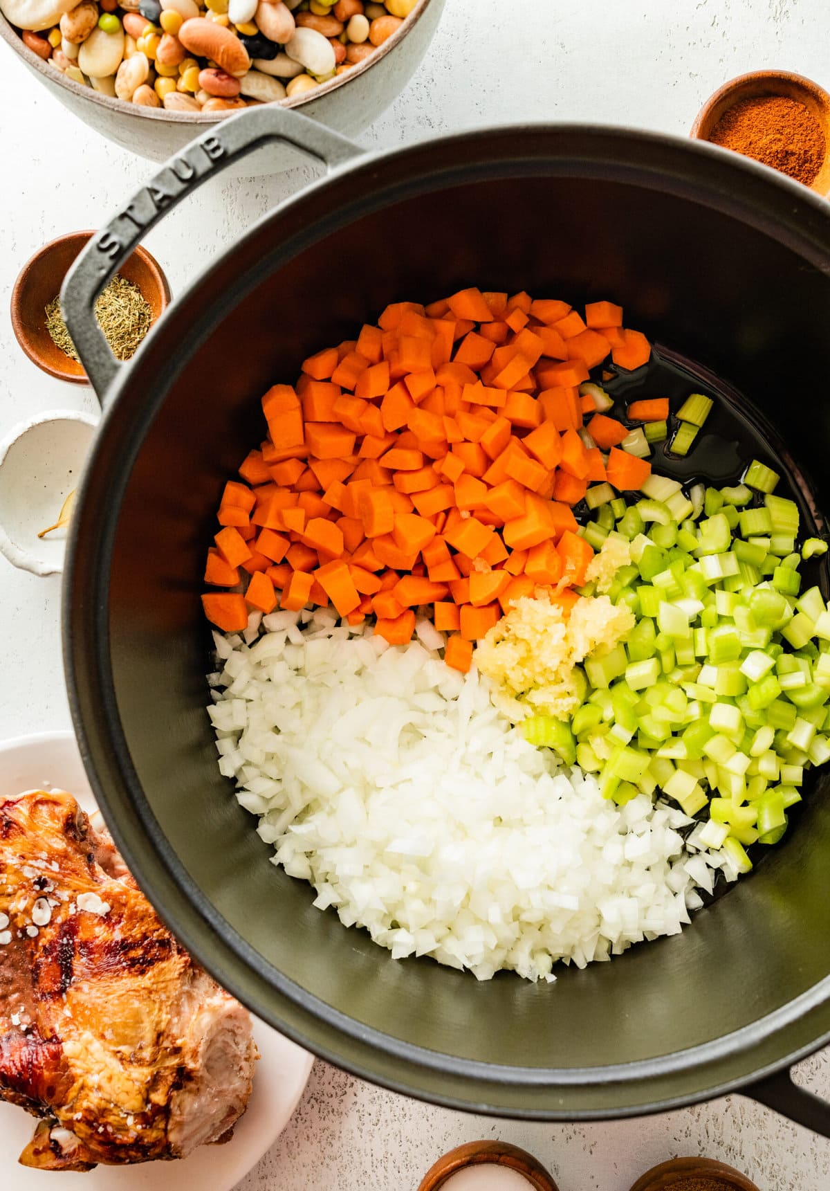 how to make 15 bean soup mix recipe with ham Step by Step: cooking onion, carrots, and celery in a cast iron pot.
