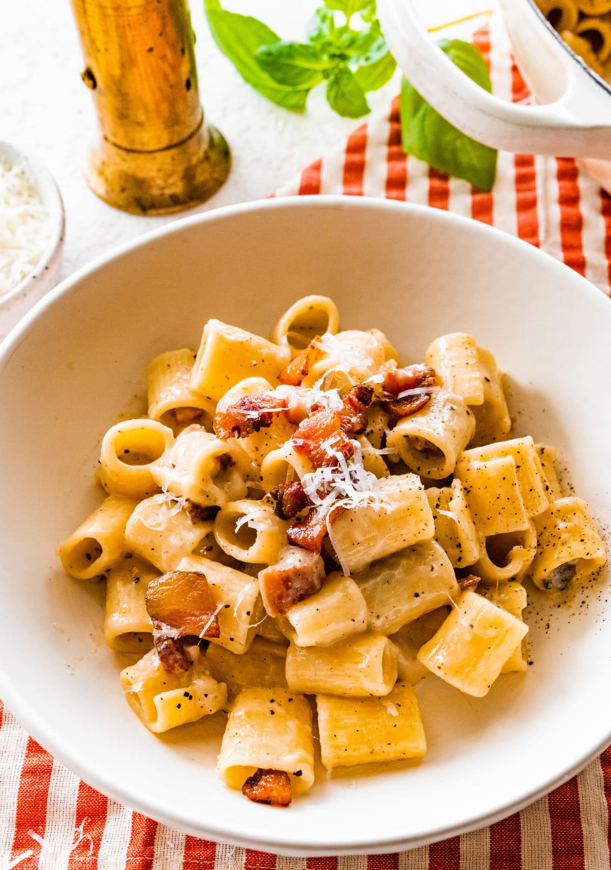 authentic pasta alla gricia on a plate with red and white checked napkin.