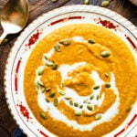 A bowl of autumn squash soup with a swirl of cream.