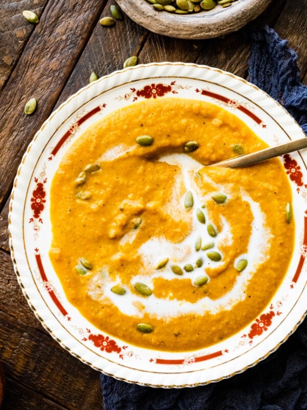 Autumn Squash Soup Recipe (Panera Copycat) in a beautiful bowl with spoon showing up close of soup.