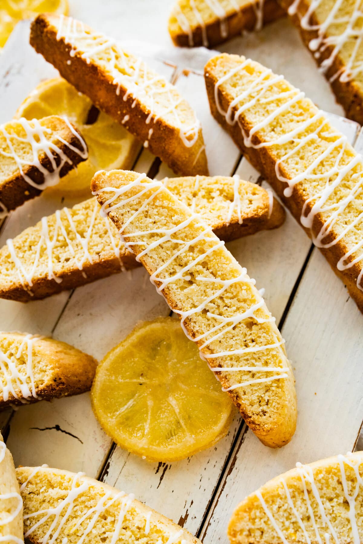 beautiful lemon biscotti on white background with lemon slices around it.