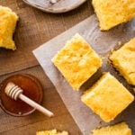plated square slices of the best sweet cornbread recipe. honey on the side.