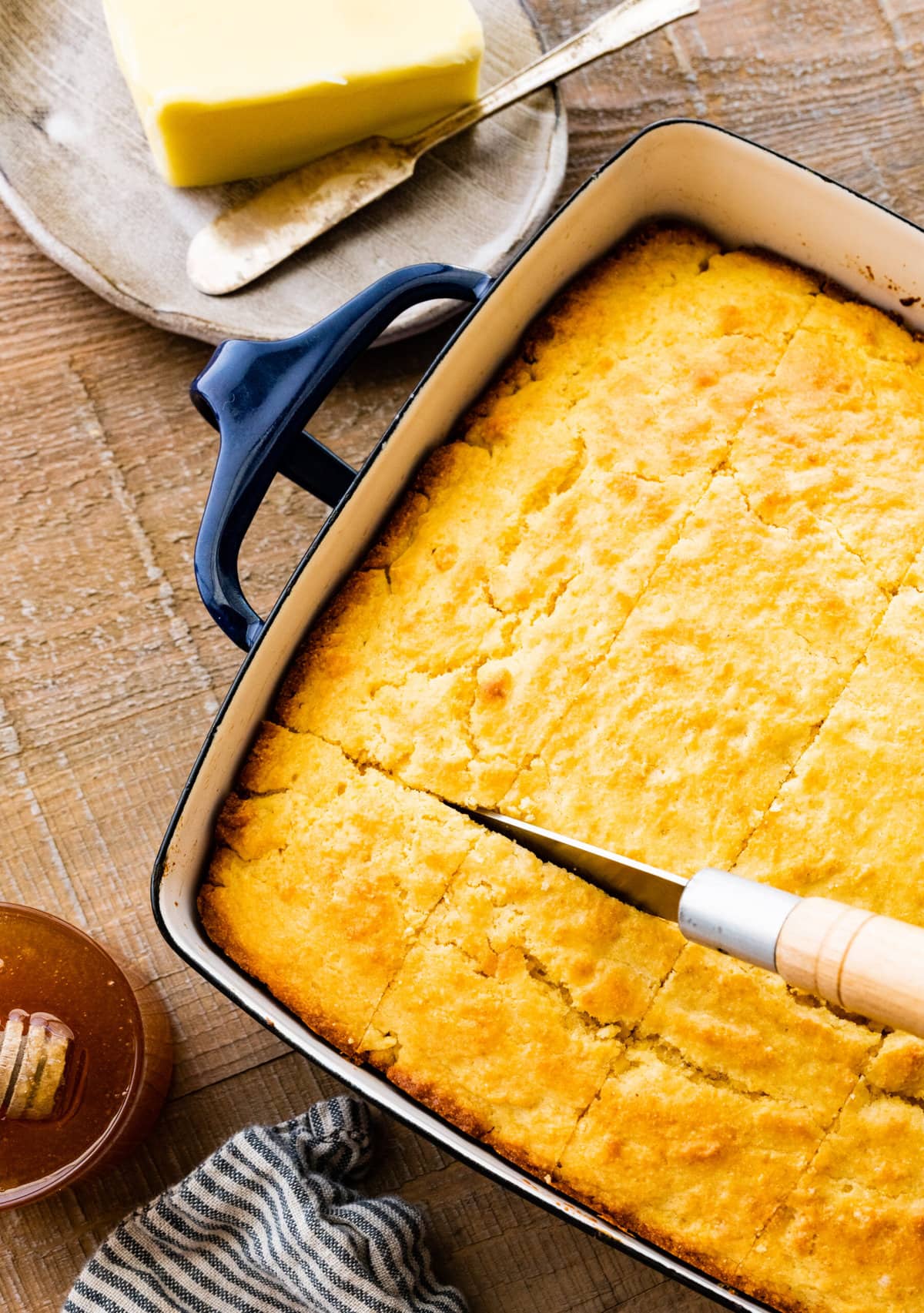 cutting the baked sweet cornbread recipe with a sharp knife.