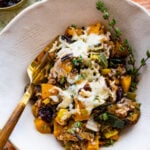 butternut squash casserole in a serving bowl with herbs.