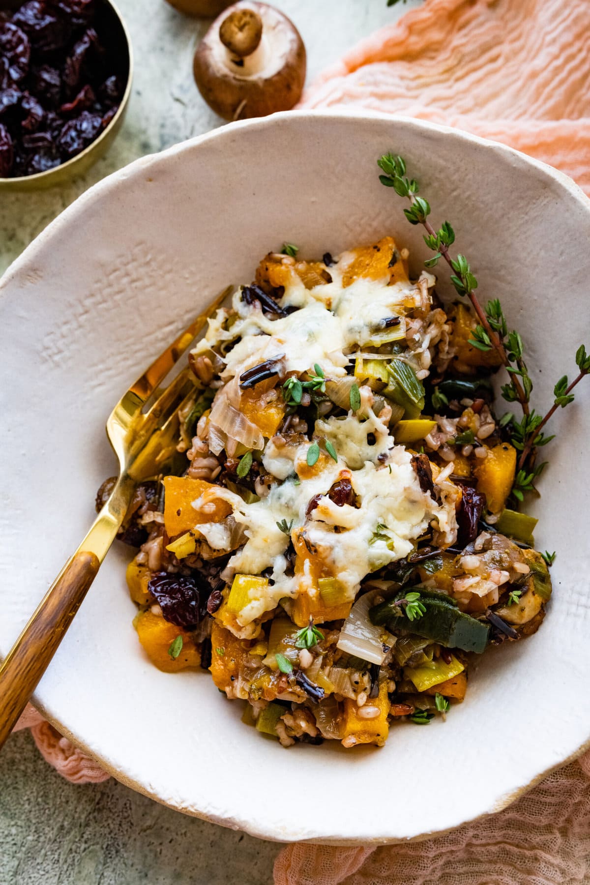 butternut squash casserole in a serving bowl with herbs.