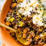 Spoon scooping from a bowl of vegetarian butternut squash casserole.