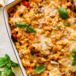 Cheesy Baked Rotini pasta after it is baked melty cheese on top with a few basil leaves.