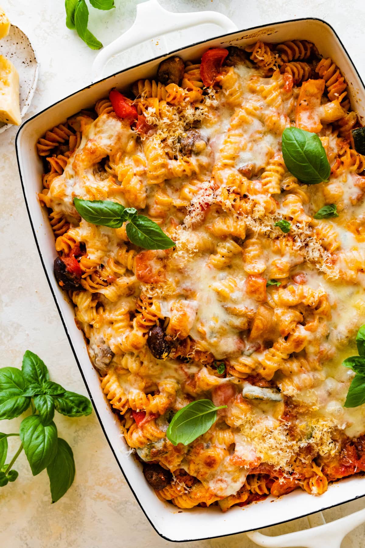 Cheesy Baked Rotini pasta after it is baked melty cheese on top with a few basil leaves.