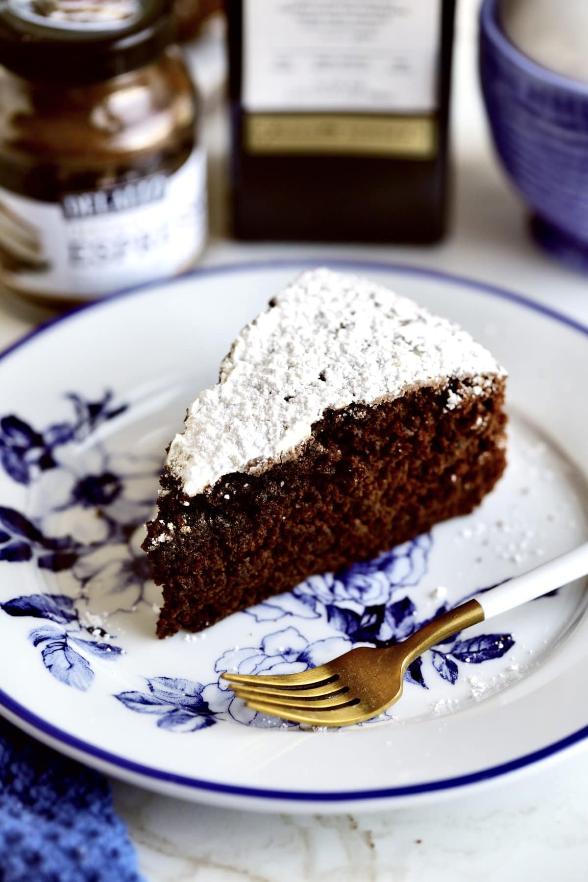 One slice of the chocolate olive oil cake on a plate with a fork. Ready to eat!