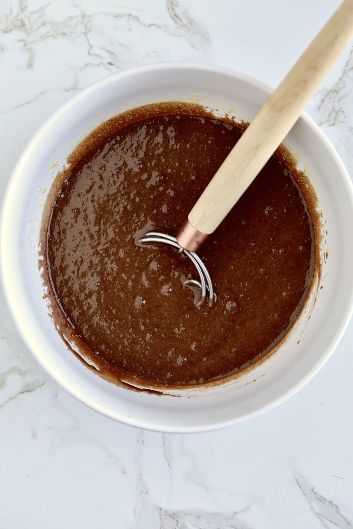 How to make chocolate olive oil cake step-by-step photos- adding the chocolate espresso mixture to the bowl with eggs mixture.