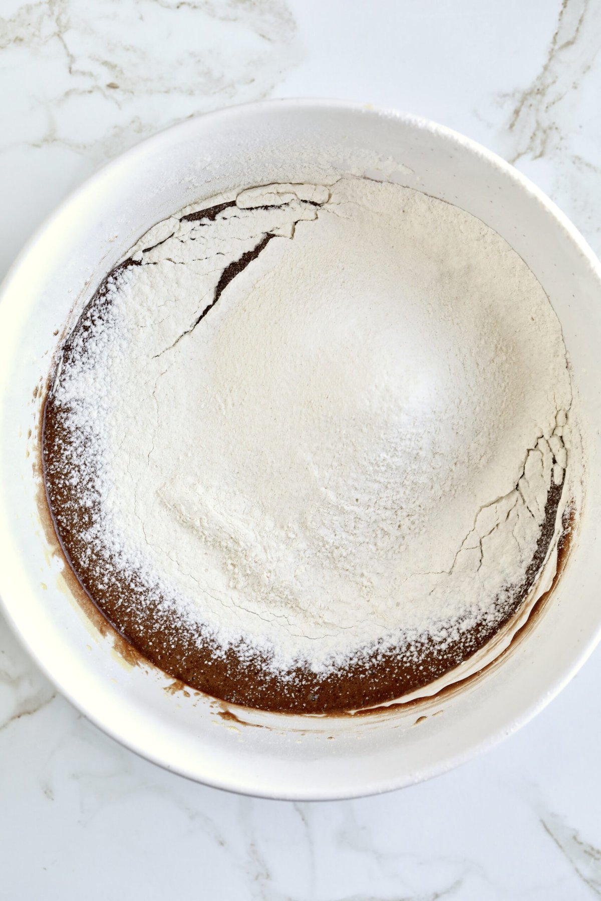 How to make chocolate olive oil cake step-by-step photos- sifting in the dry ingredients.