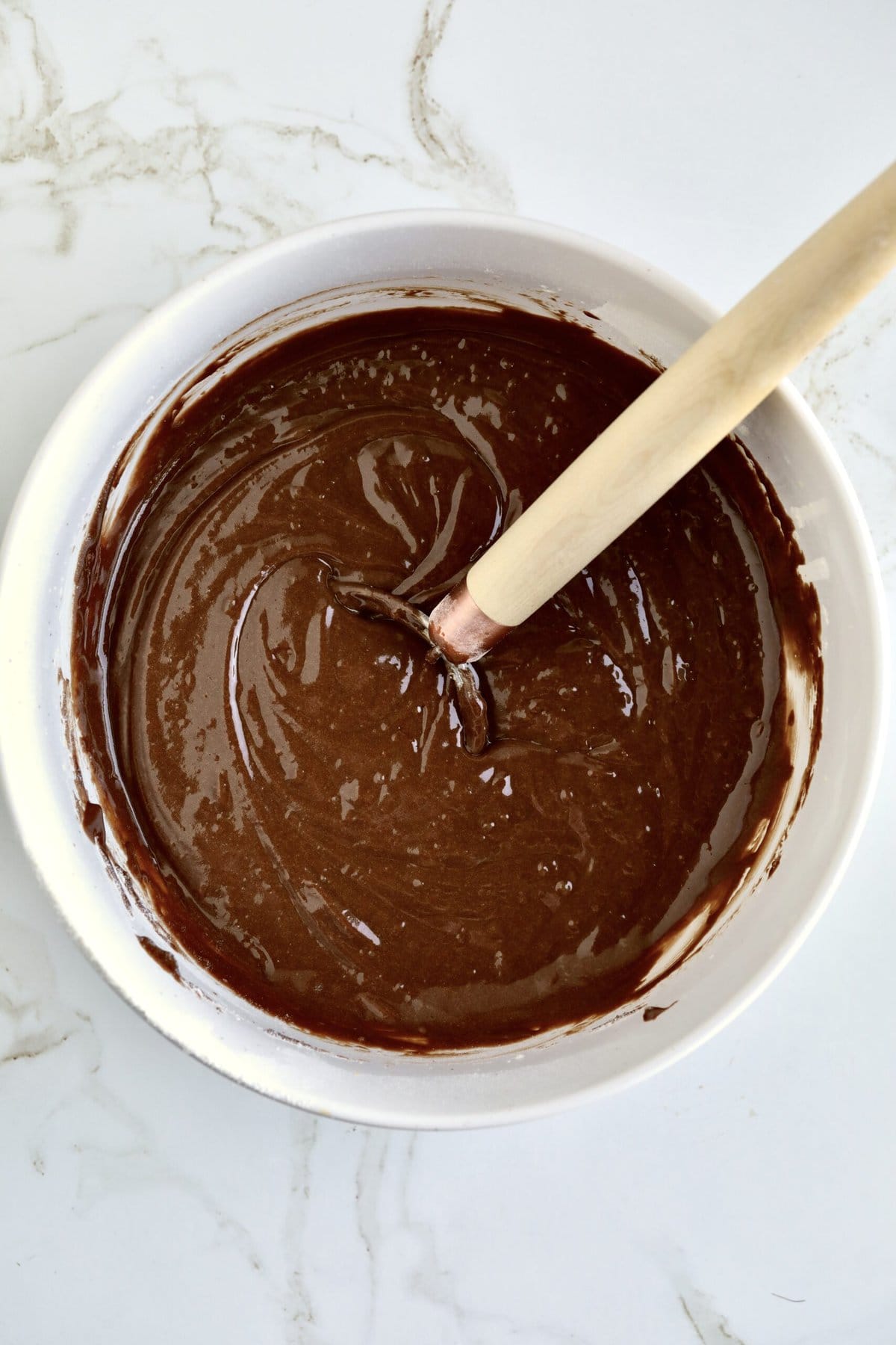 How to make chocolate olive oil cake step-by-step photos- mixing the dry and wet ingredients together in a bowl. Whisk in the bowl.