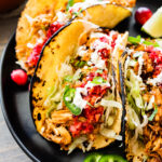 Leftover turkey tacos on a black plate.