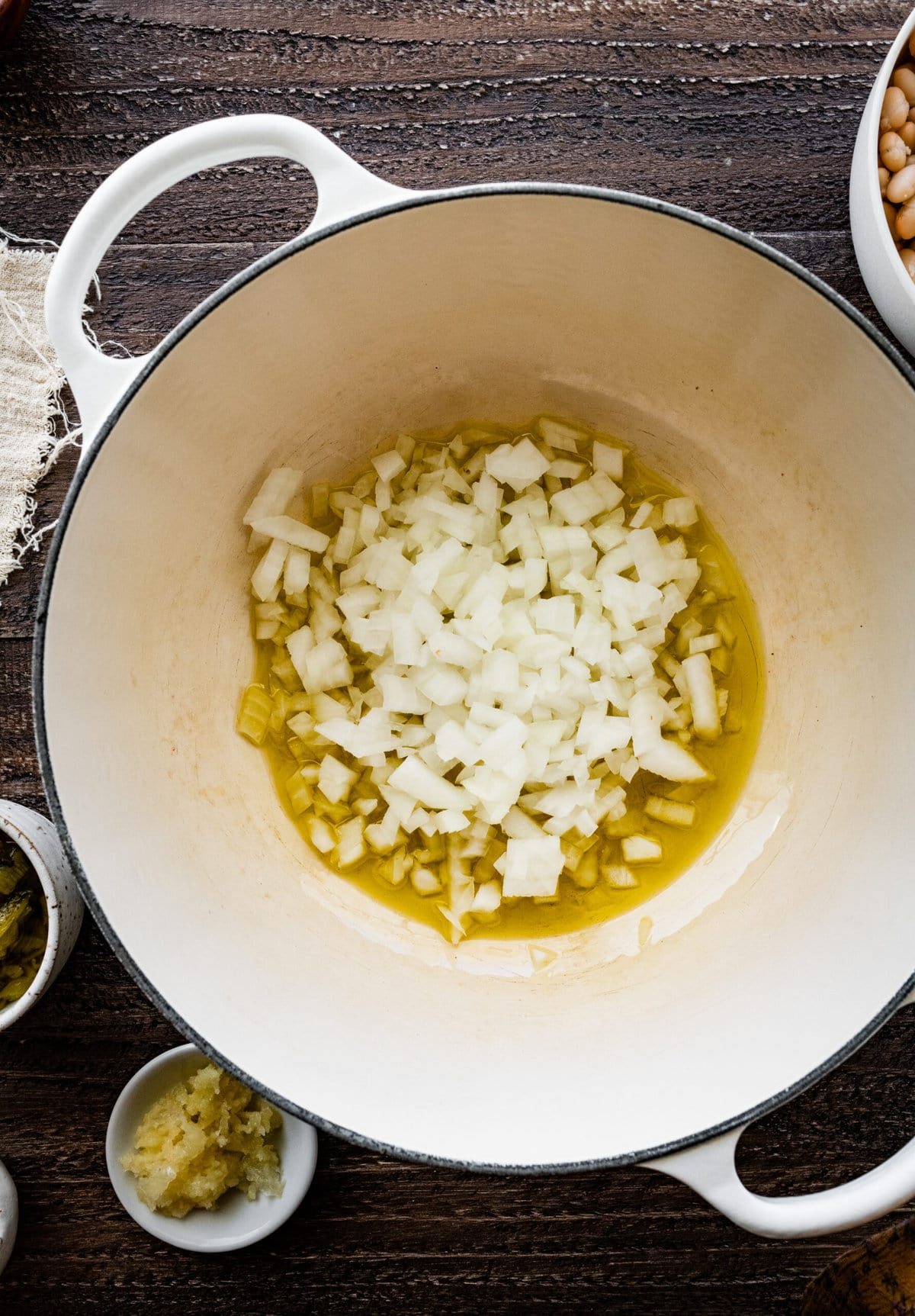 How to make Healthy White Chicken chili recipe step by step: sauté onions and garlic in olive oil.