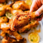 hand holding chicken drumstick ready to eat.