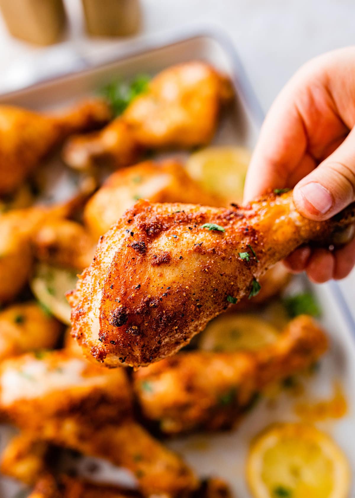 hand holding chicken drumstick ready to eat.