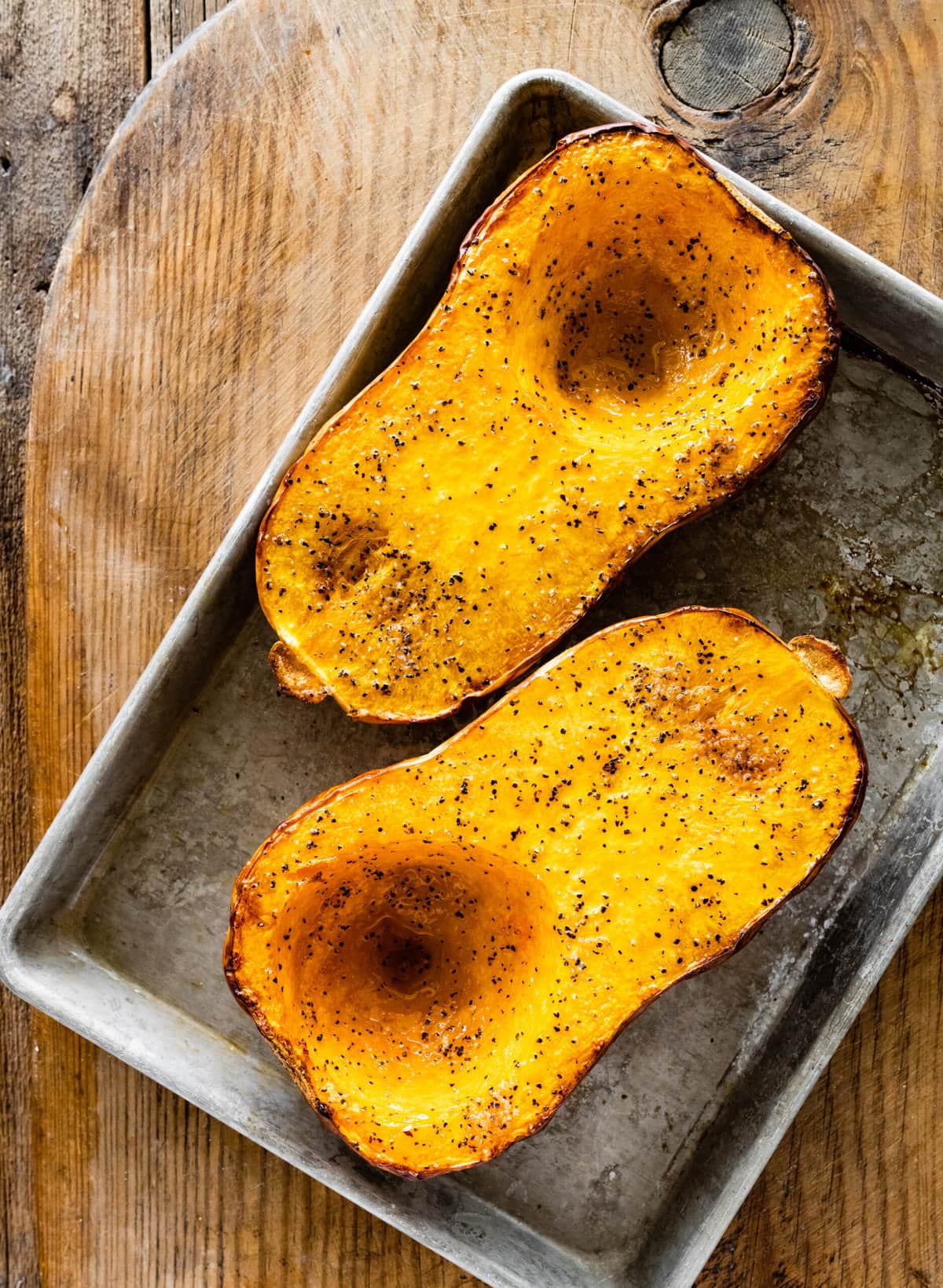 How to Cook Butternut Squash Whole in Oven Recipe- baked squash after seasoning on baking sheet.