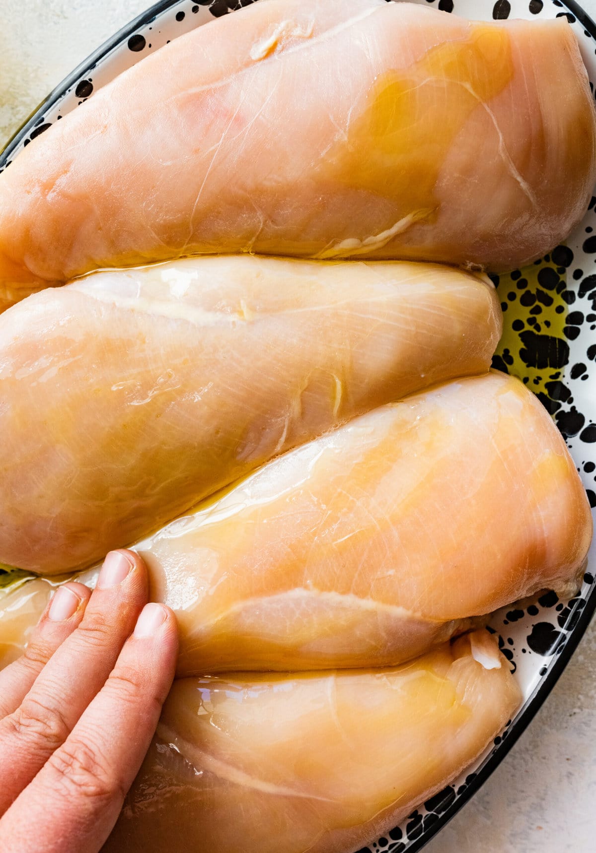 rubbing the chicken breast with oil.