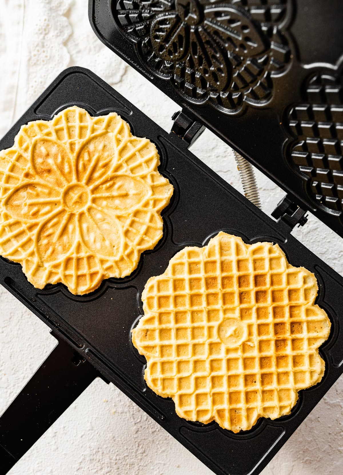 How to make best pizzelle cookie recipe step-by-step: pressing the cookies in the pizzelle iron.