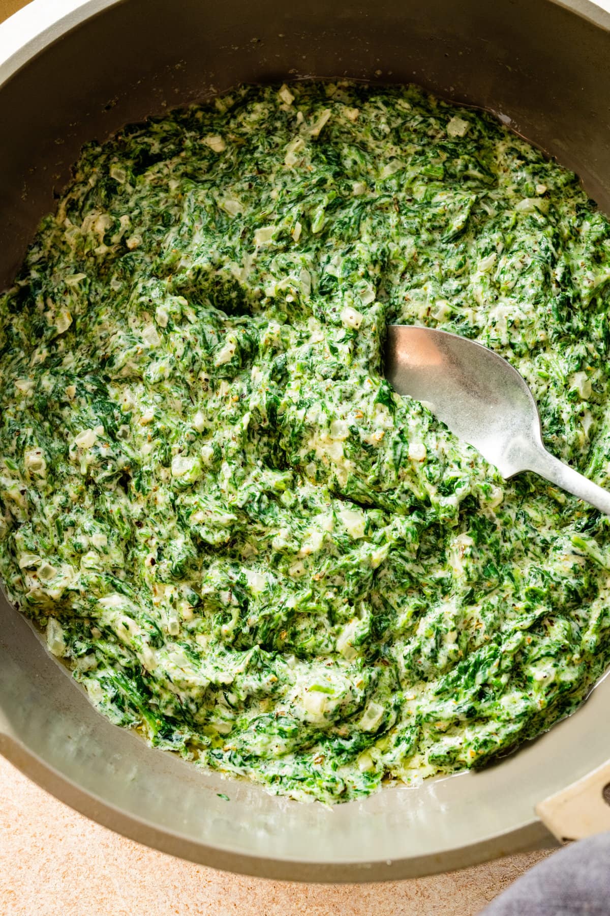 creamed spinach with a spoon on it.