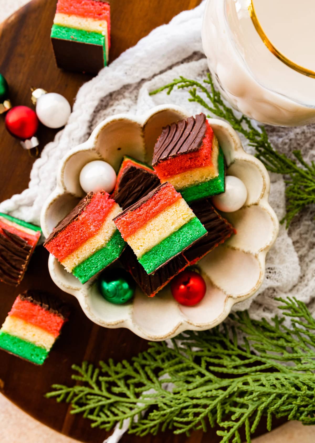 plate of Classic Italian Rainbow Cookies Recipe with cute Christmas ornaments around the platter.