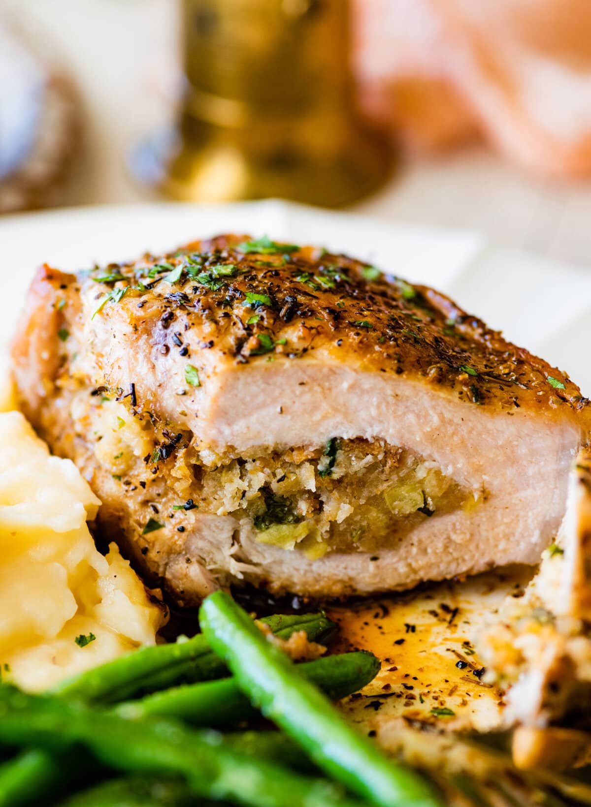 stuffed pork chop cut open to see filling with green beans and mashed potatoes.