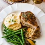 stuffed pork chop cut open to see filling with green beans and mashed potatoes.
