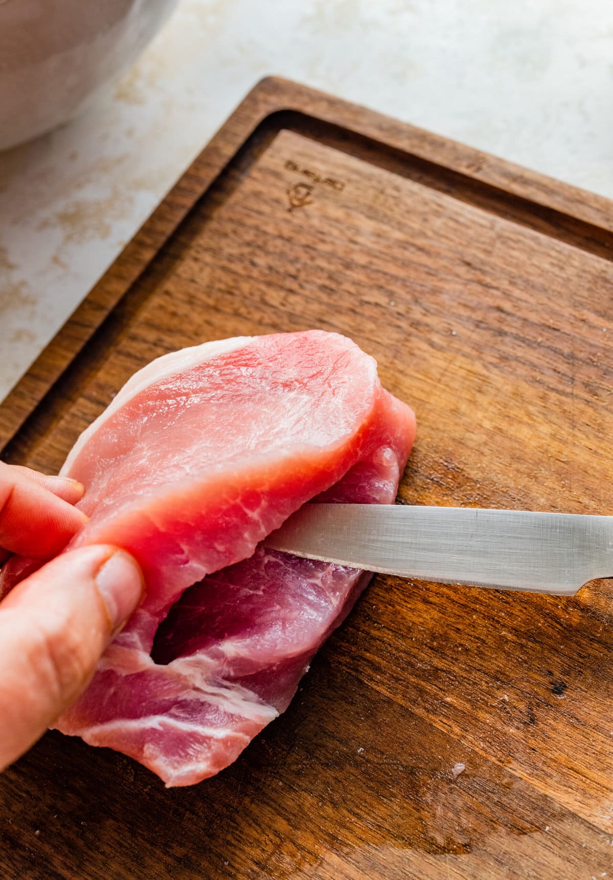 how to make Oven Baked Stuffed Pork Chops Recipe: cutting the pork to make a pocket for the filling.