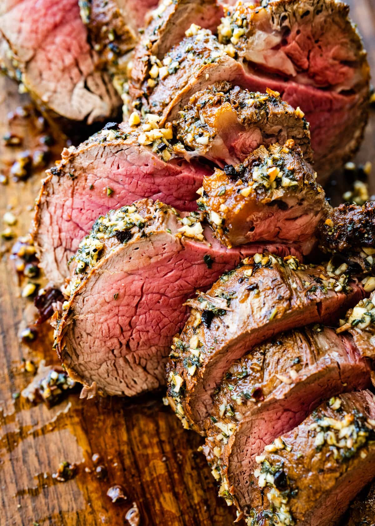 How to make perfect roast beef tenderloin- cutting the meat into slices on a cutting board.