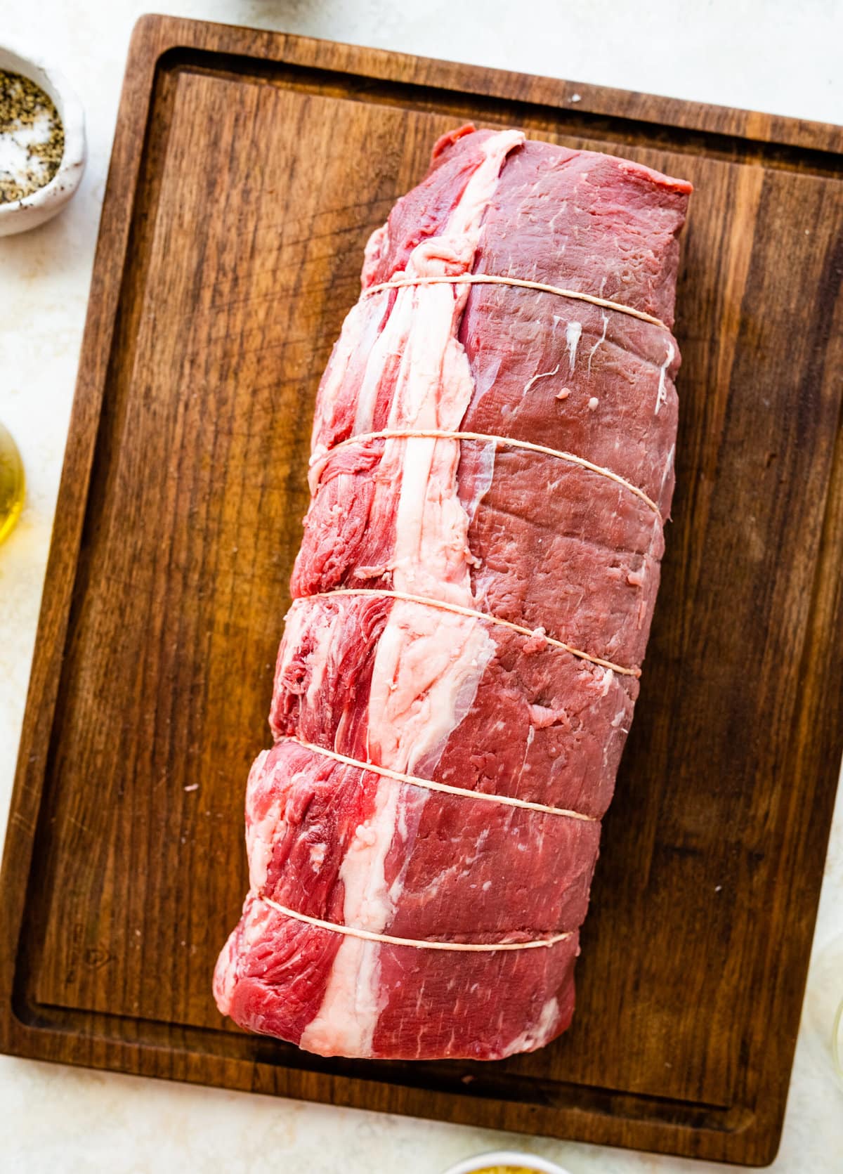 How to make perfect roast beef tenderloin- meat on cutting board. Seasoned meat.