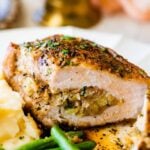 stuffed pork chop cut open to see filling with green beans and mashed potatoes.