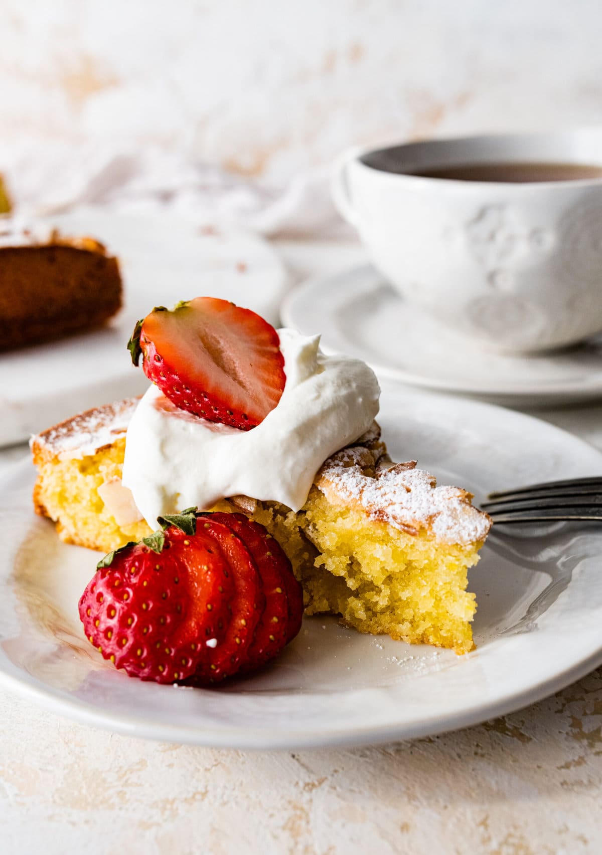 easy almond cake recipe on a plate with a fork taking a bite.