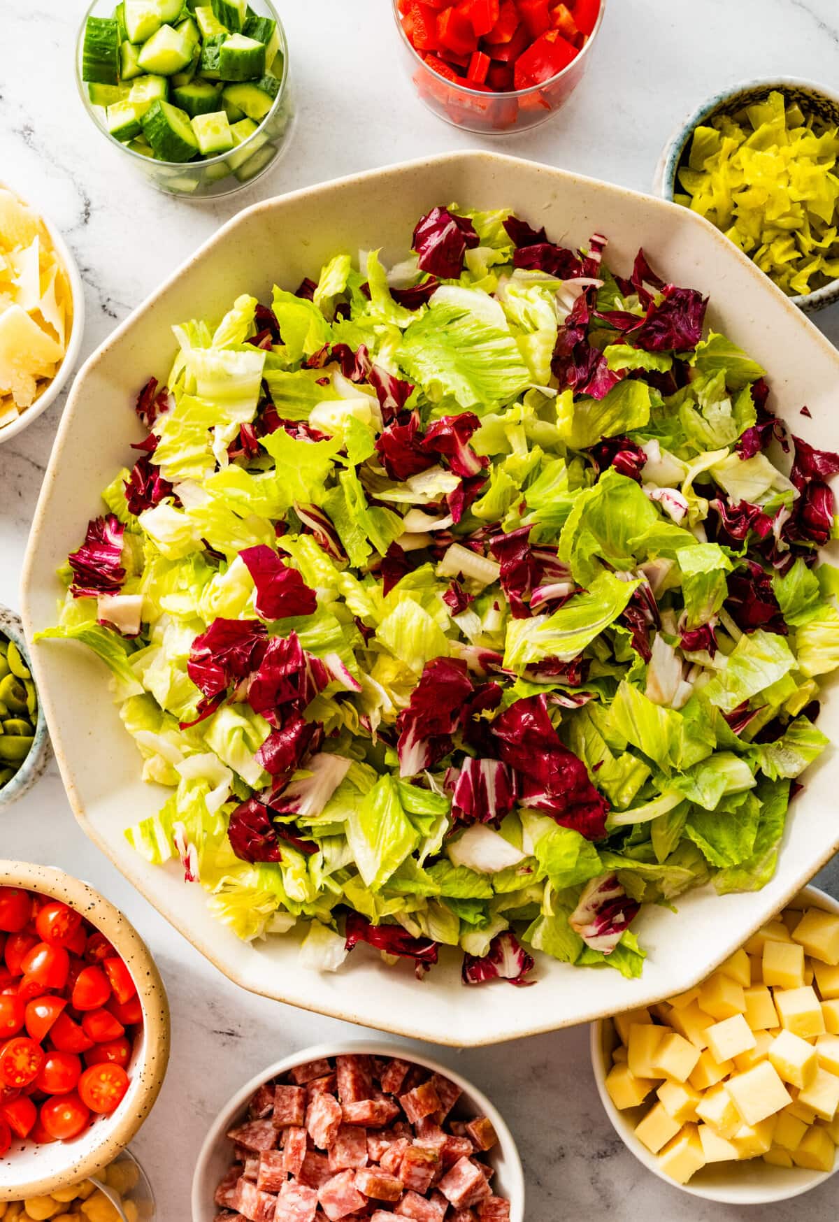 how to make Italian chopped salad step-by-step: adding the salad as the base in the bowl.