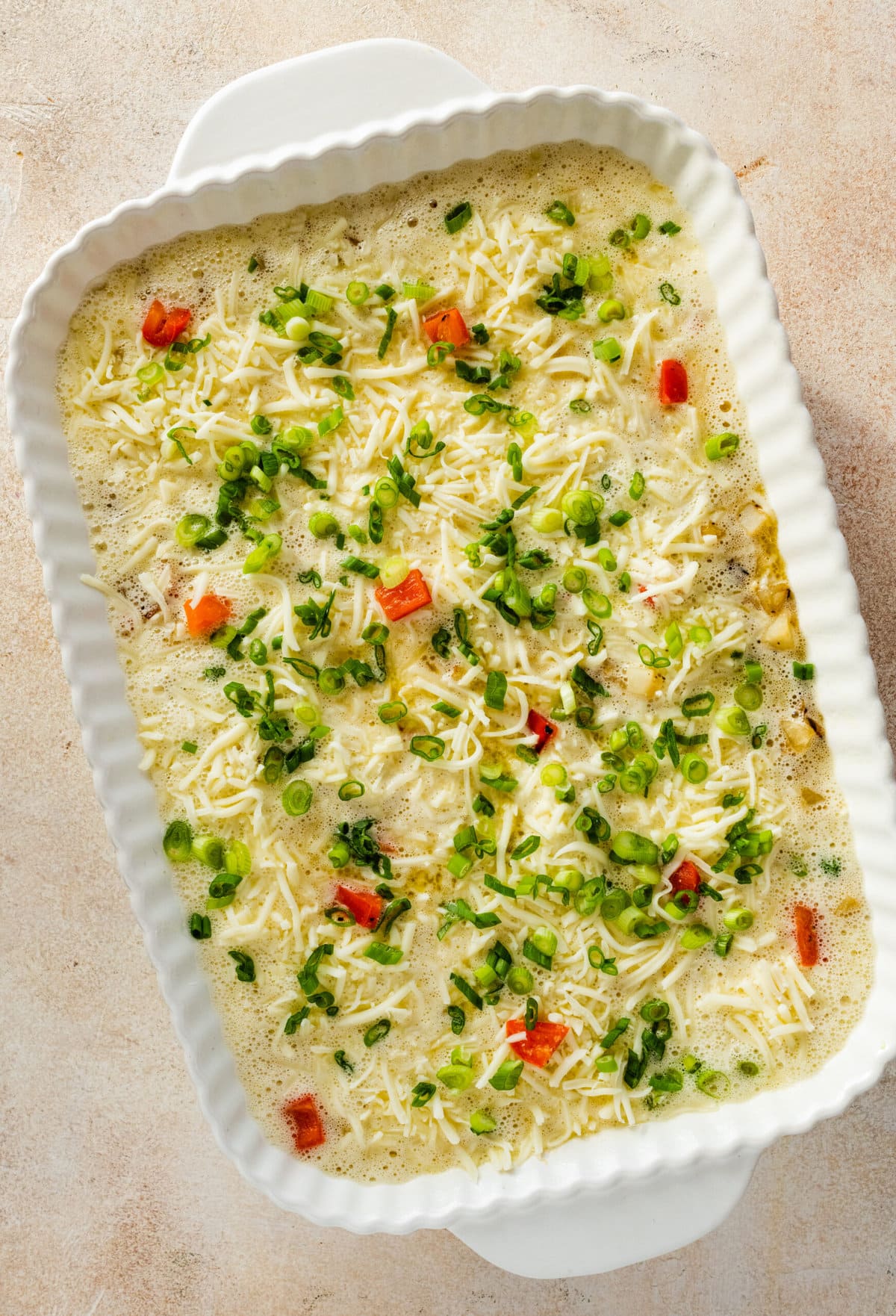How to make breakfast casserole step-by-step: add the egg and cheese mixture and top with green onions and bake.
