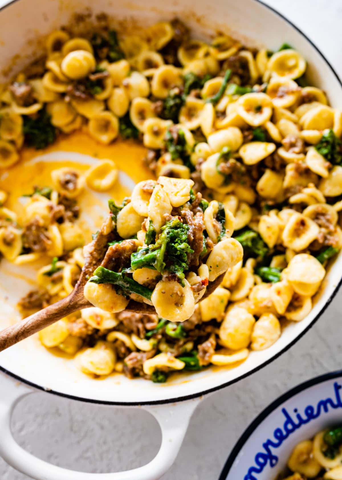 wooden spoon taking a portion of the prepared pasta to serve.