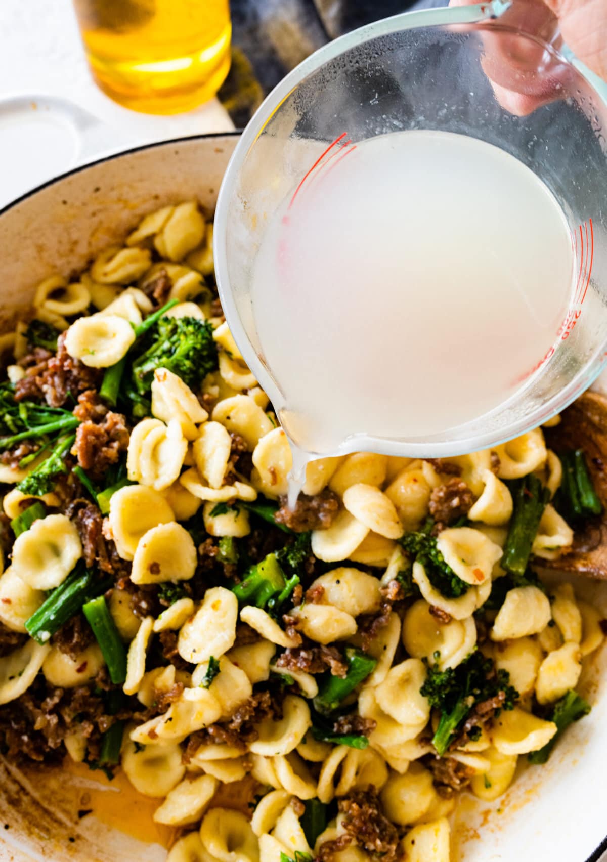 how to make Easy Orecchiette with Sausage and Broccoli- step-by-step: add cooked orecchiette pasta and pasta water to the broccoli to the sausage.