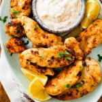 Plate of pan-fried chicken tenders and dip.