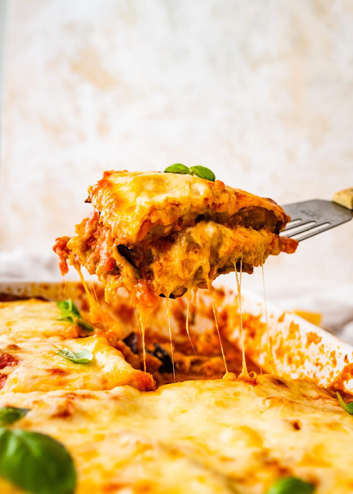 slice of eggplant parmigiana lifted out of the pan with a cheese pull.