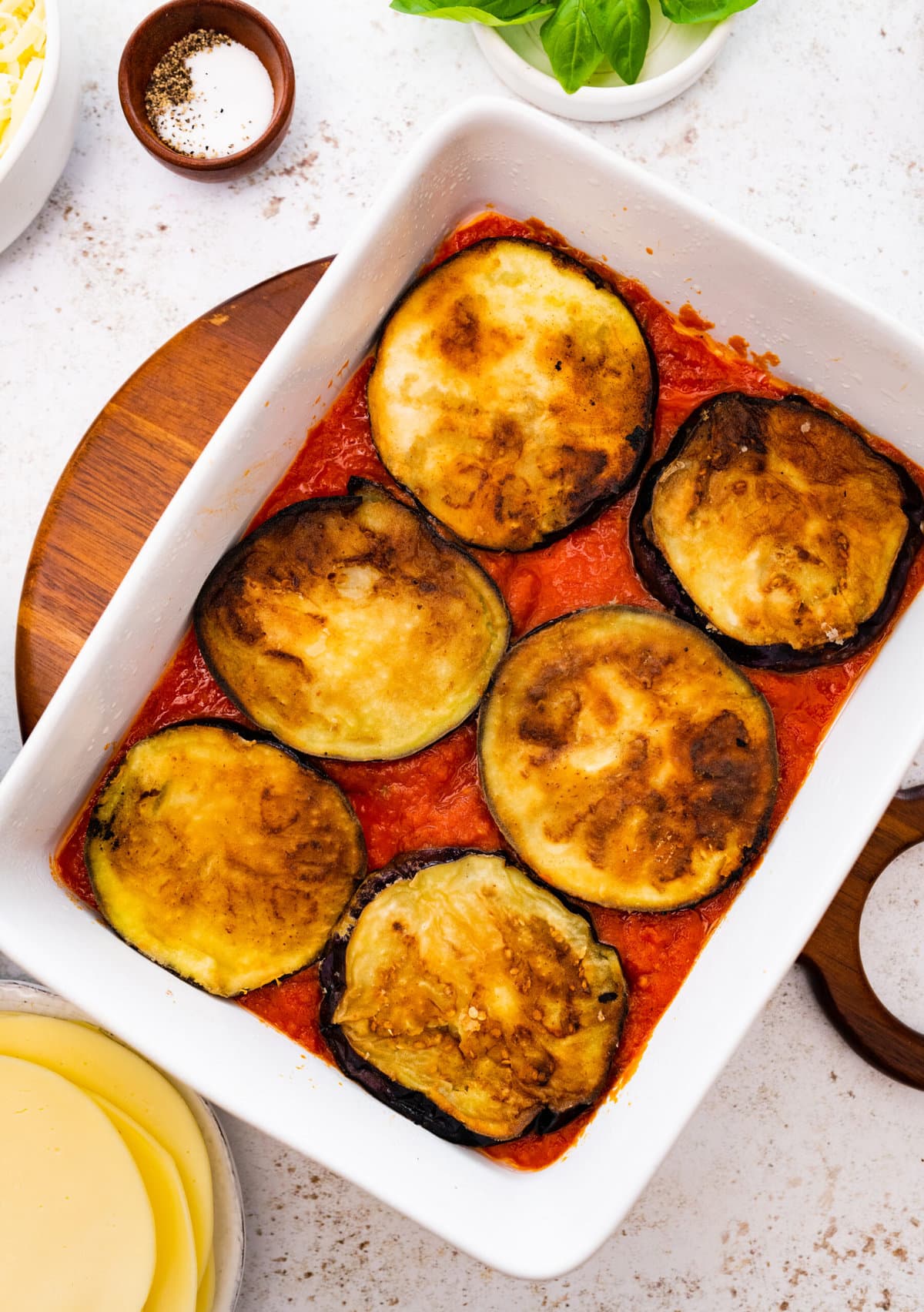 how to make eggplant parmigiana step-by-step: layering the fried eggplant on top of the homemade sauce.