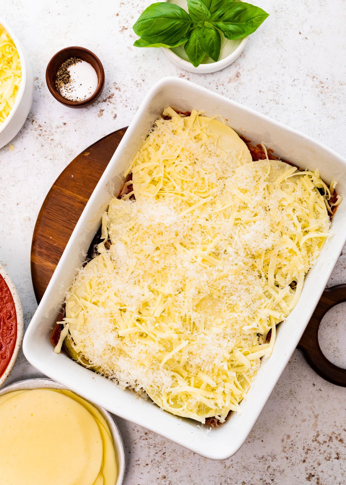 how to make eggplant parmigiana step-by-step: adding layers of both cheeses on top of the eggplant.