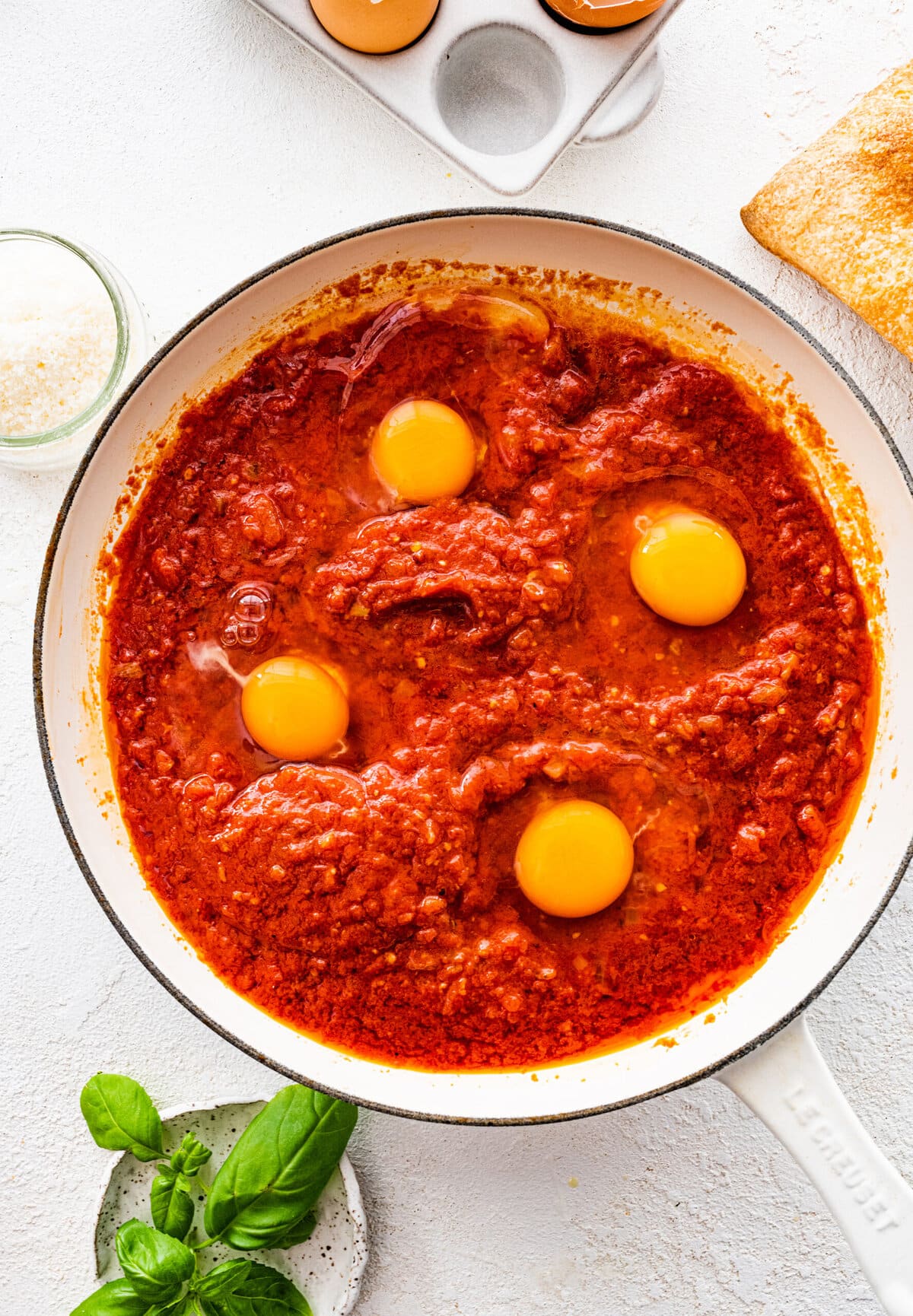 How to make Italian Eggs in Purgatory step-by-step instructions: make little wells and add the eggs in the sauce.