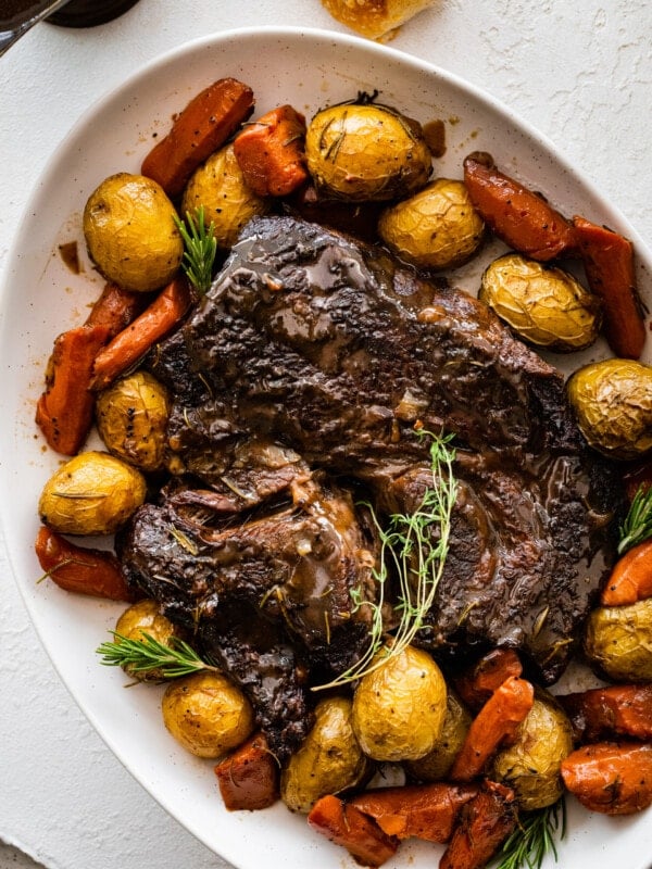 Pot roast on a tray with roasted vegetables.