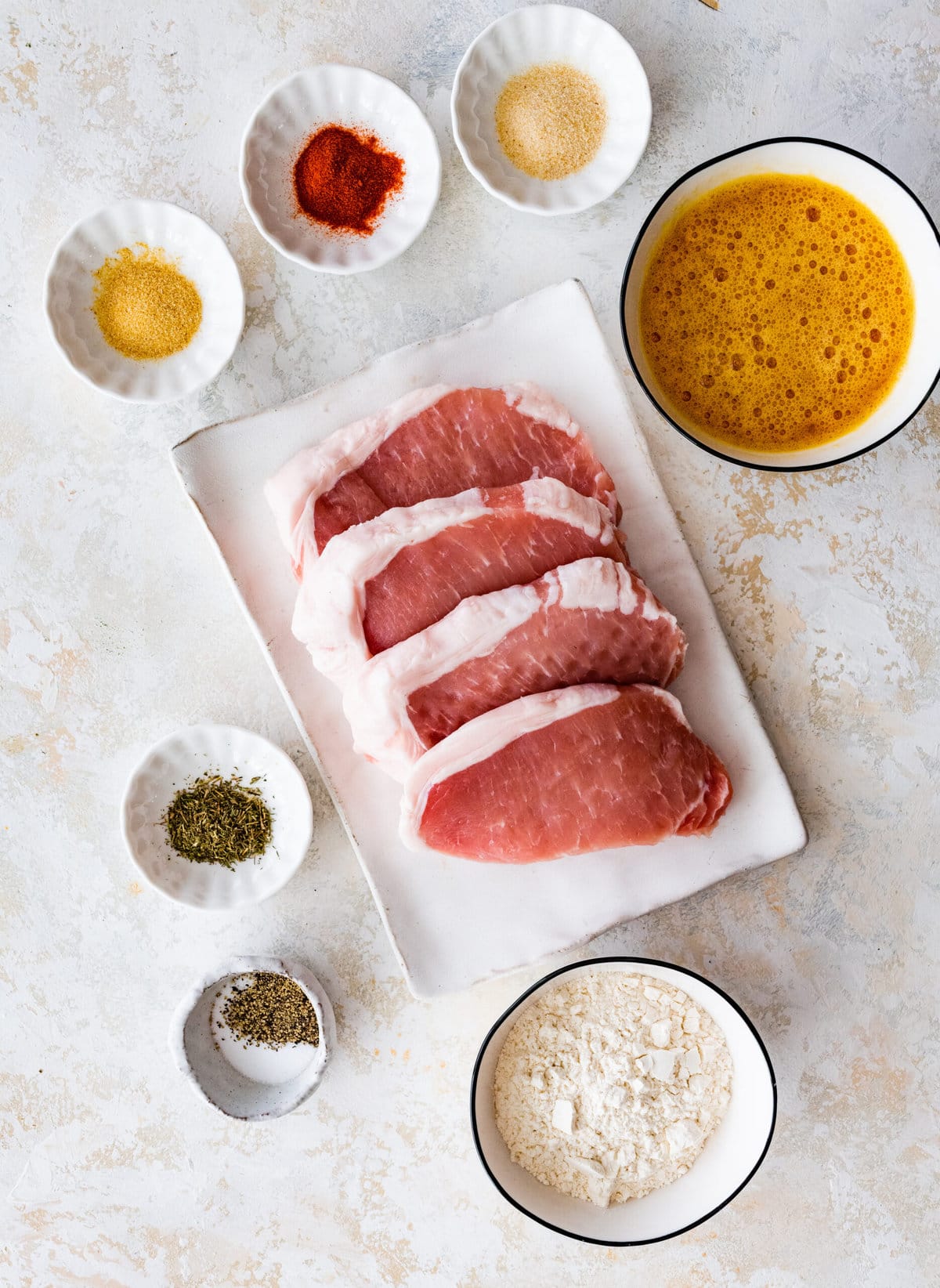Breaded fried pork chop ingredients including eggs, flour, and paprika.