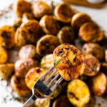 Fork holding a crispy potato ready to eat.