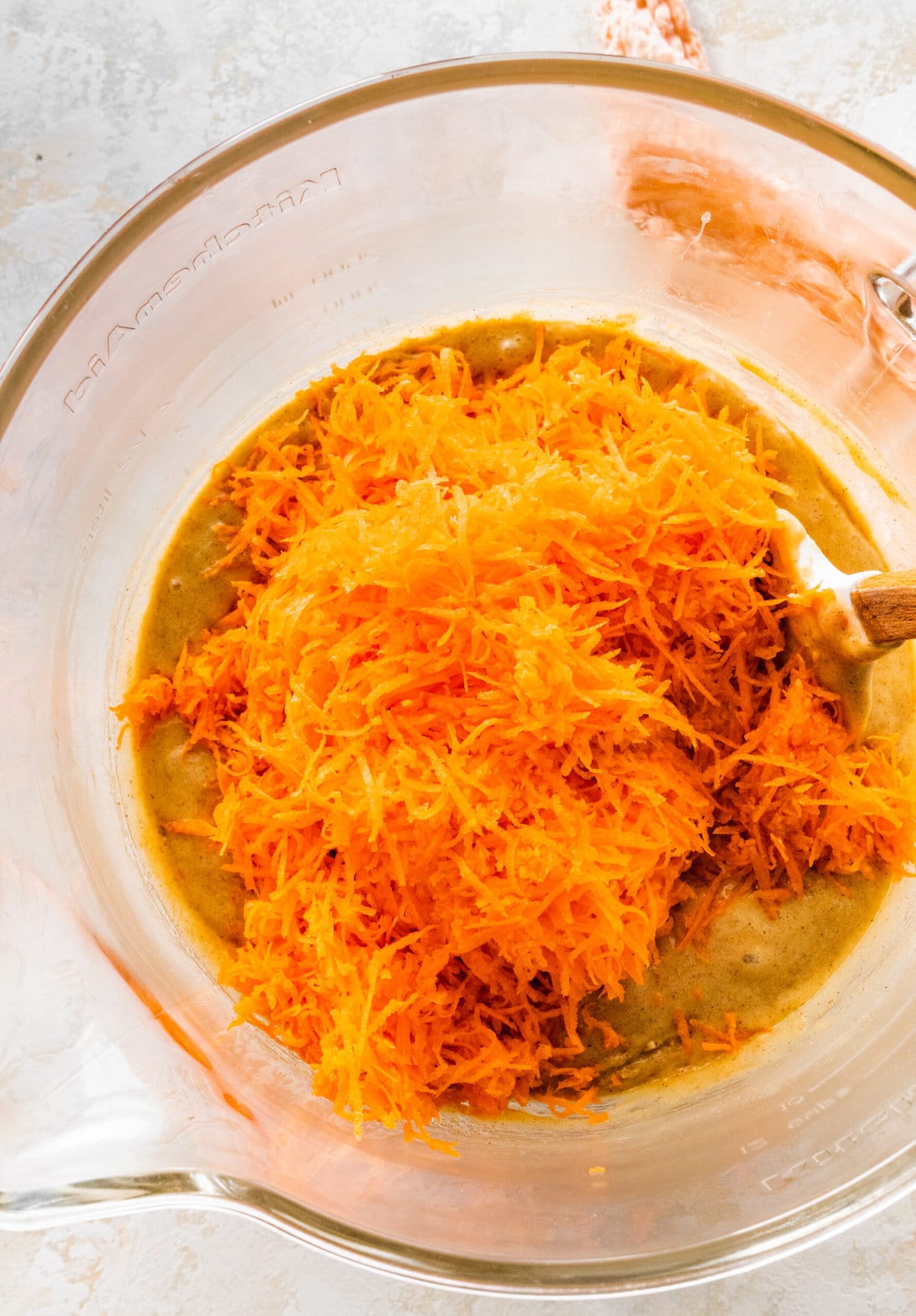 How to make easy carrot cake step-by-step photos: adding the shredded carrots and the oil to the batter.