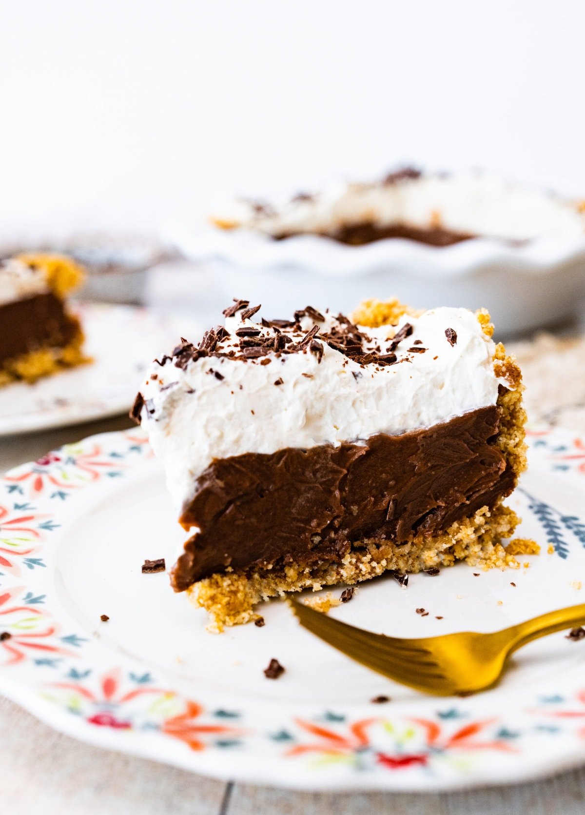 slice of pie on a plate with pretty flower designed edges. Fork on plate.